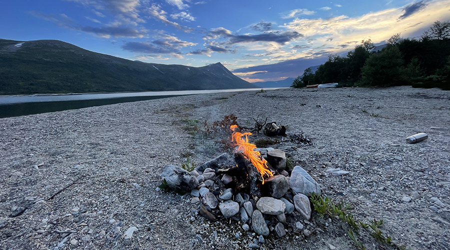 Bål på steinstrand som brenner